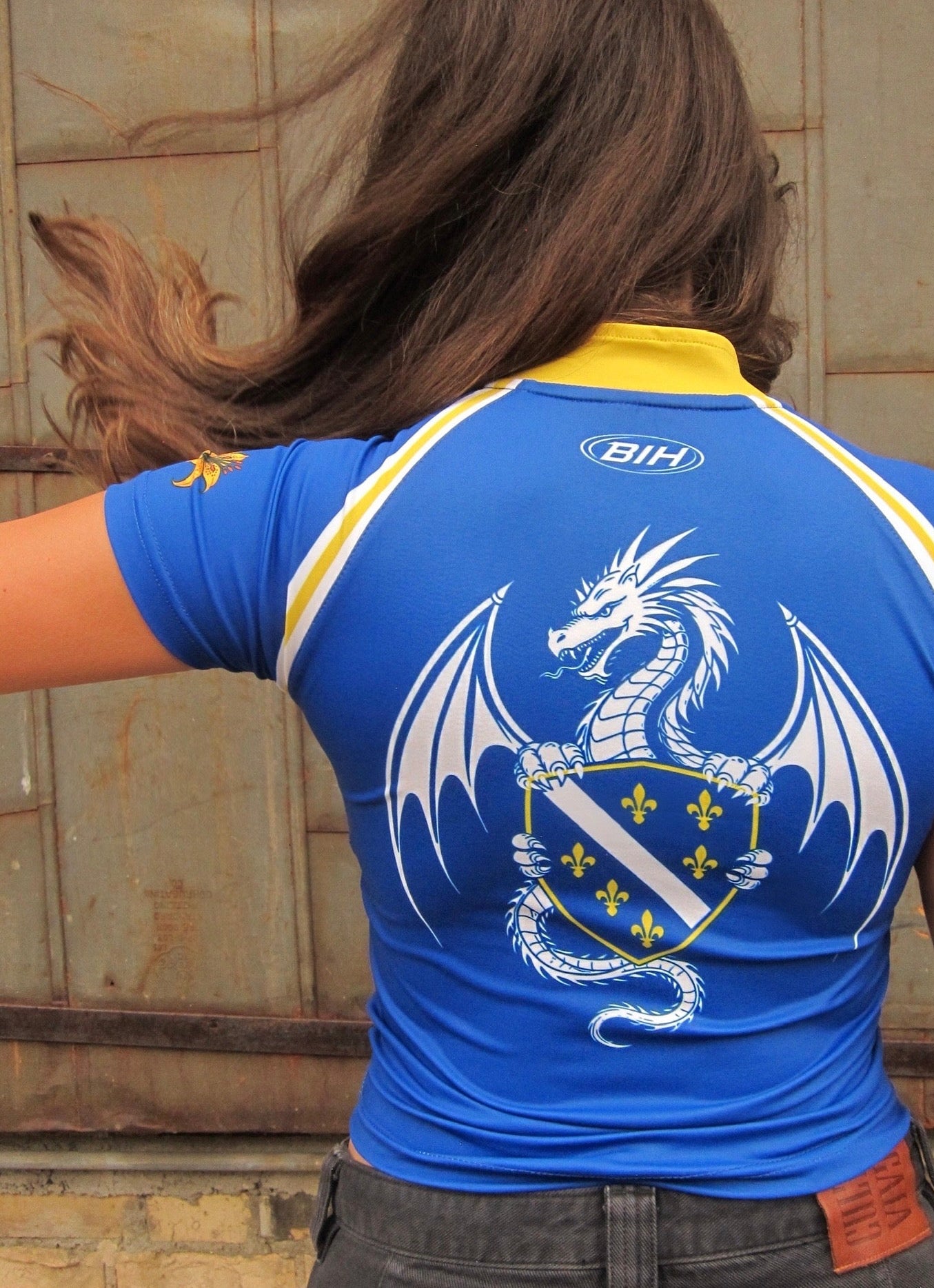 Person wearing a cute and trendy Bosnia and Herzegovina sports jersey with a dragon design and BiH logo.